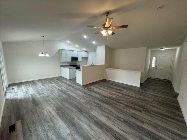 kitchen featuring ceiling fan with notable chandelier, stainless steel appliances, dark wood-type flooring, and open floor plan