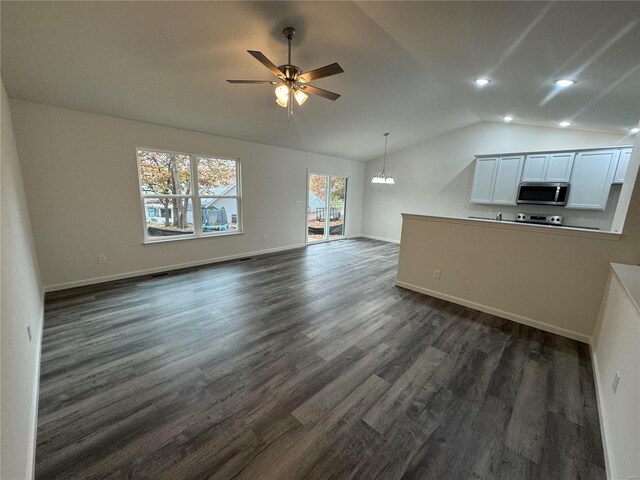 unfurnished living room with dark wood-style flooring, ceiling fan with notable chandelier, recessed lighting, baseboards, and lofted ceiling