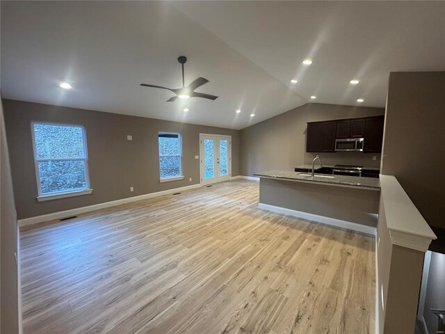 kitchen featuring open floor plan, light wood-style flooring, lofted ceiling, and stainless steel appliances