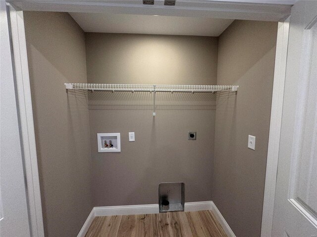 laundry area with electric dryer hookup, baseboards, laundry area, and wood finished floors