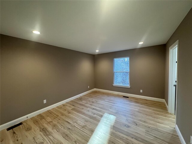empty room with baseboards, recessed lighting, light wood-style flooring, and visible vents