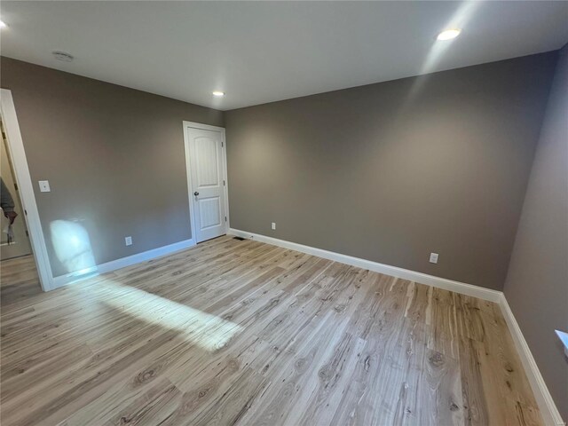 spare room with light wood-style floors, recessed lighting, and baseboards