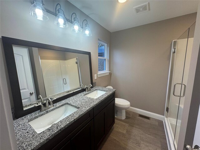 bathroom with visible vents, a sink, and a shower stall