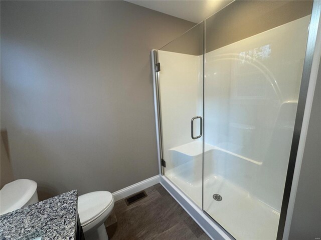 bathroom with baseboards, a stall shower, toilet, and visible vents