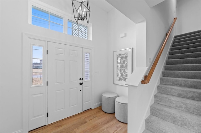 entrance foyer featuring stairs, plenty of natural light, and light wood-style flooring