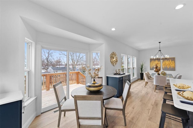 dining room featuring a notable chandelier, a healthy amount of sunlight, and light wood-style flooring