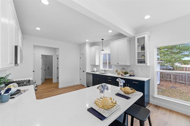 kitchen featuring light countertops, stainless steel appliances, a sink, and light wood-style floors
