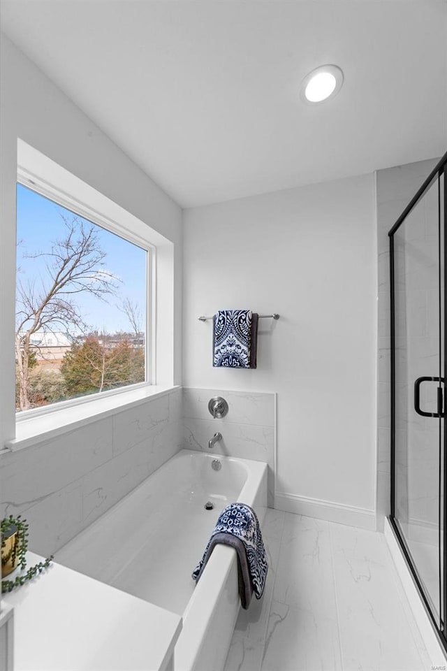 full bath featuring baseboards, a stall shower, a bath, and marble finish floor