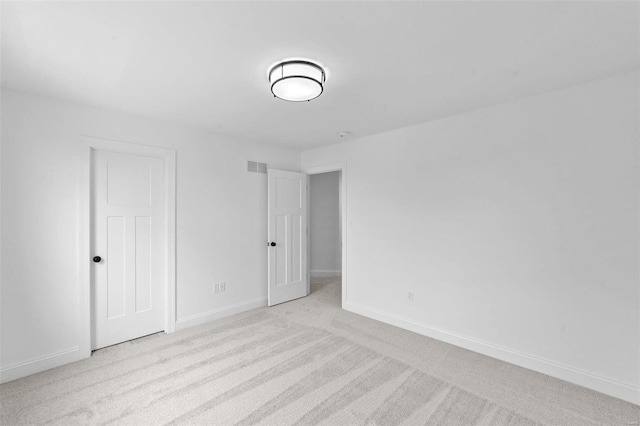 unfurnished bedroom with carpet floors, baseboards, and visible vents