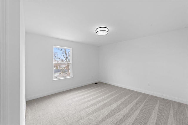 unfurnished room with carpet floors, baseboards, and visible vents
