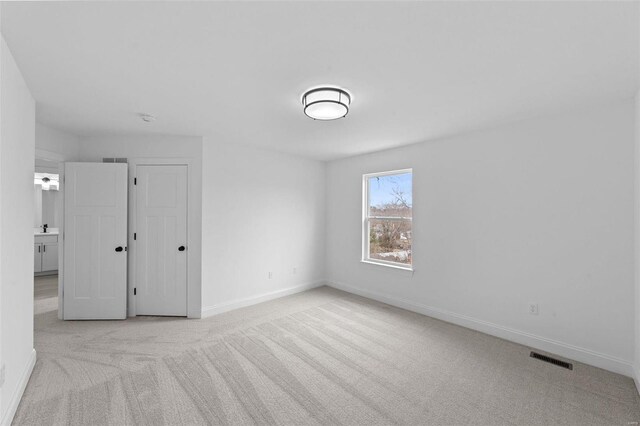 unfurnished bedroom featuring carpet floors, baseboards, and visible vents