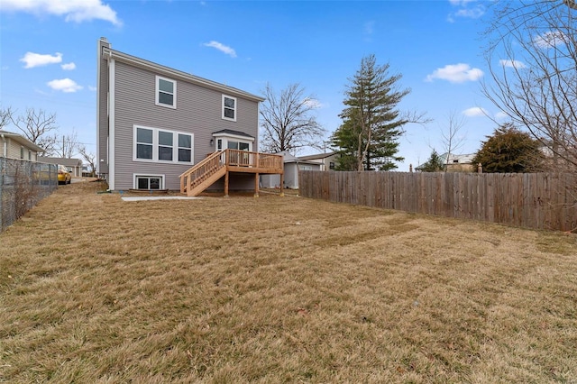 back of house featuring a fenced backyard, a wooden deck, a yard, and stairway