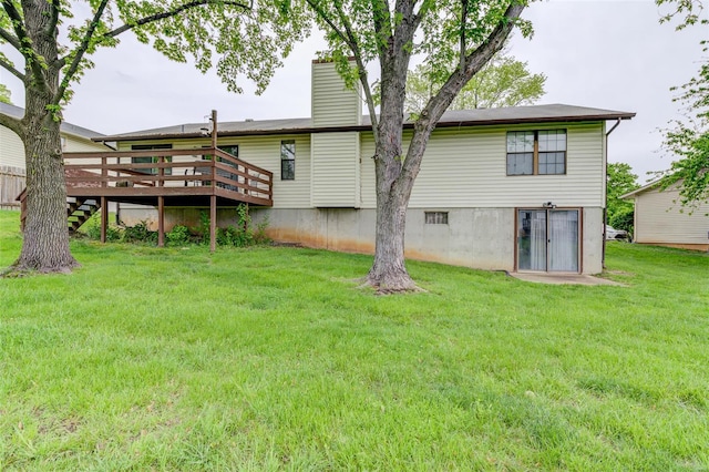 back of property featuring a yard, a chimney, a wooden deck, and stairs