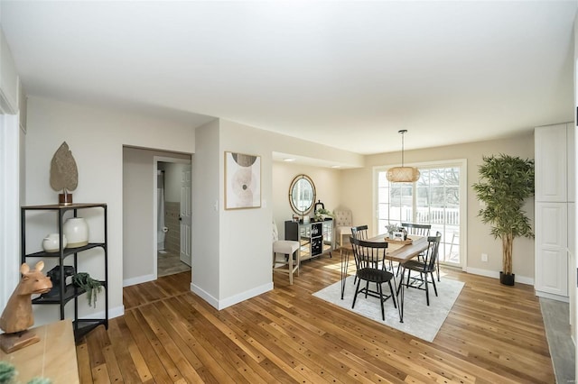 dining area with light wood-style floors and baseboards