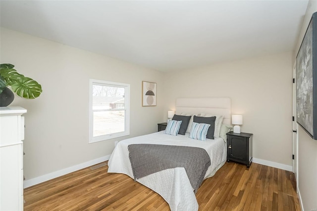 bedroom with baseboards and wood finished floors