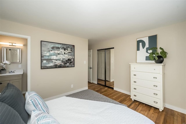 bedroom featuring baseboards, wood finished floors, and ensuite bath