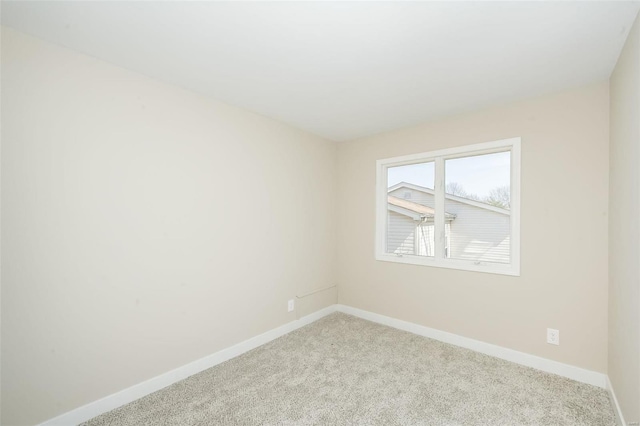 empty room featuring light colored carpet and baseboards