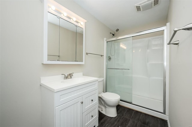 full bath with vanity, a stall shower, toilet, and visible vents