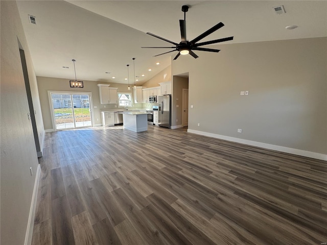 unfurnished living room featuring vaulted ceiling, visible vents, baseboards, and a ceiling fan