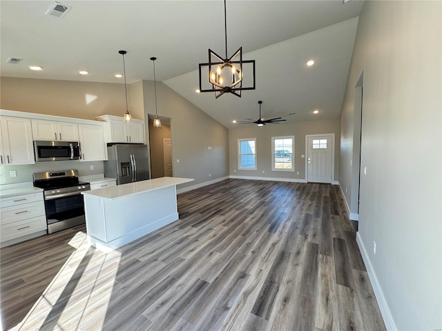 kitchen featuring high vaulted ceiling, white cabinetry, light countertops, baseboards, and appliances with stainless steel finishes