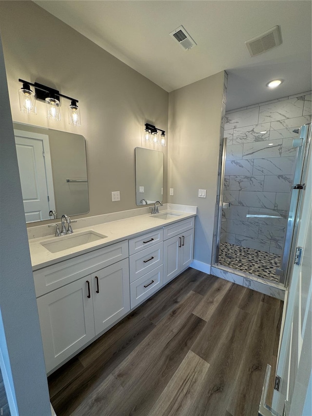 bathroom with visible vents, a shower stall, and a sink