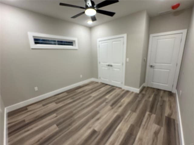 unfurnished bedroom featuring baseboards, ceiling fan, and wood finished floors