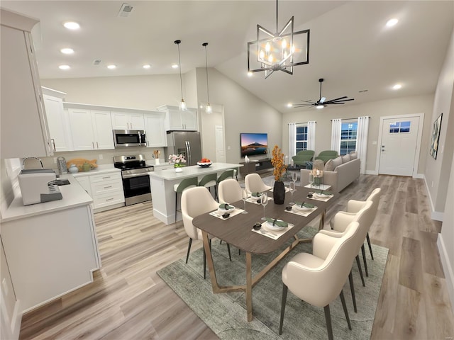 dining space with recessed lighting, visible vents, ceiling fan with notable chandelier, high vaulted ceiling, and light wood-type flooring
