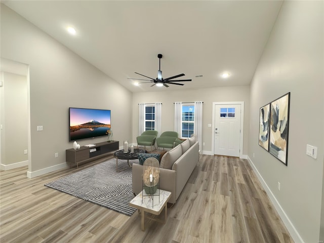 living room with a ceiling fan, recessed lighting, baseboards, high vaulted ceiling, and light wood-type flooring