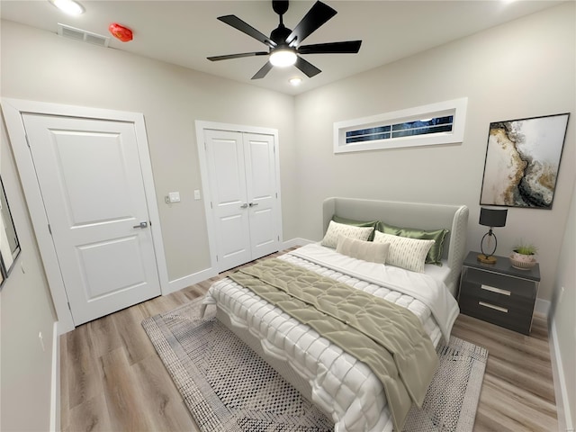 bedroom with a ceiling fan, a closet, light wood-style flooring, baseboards, and visible vents