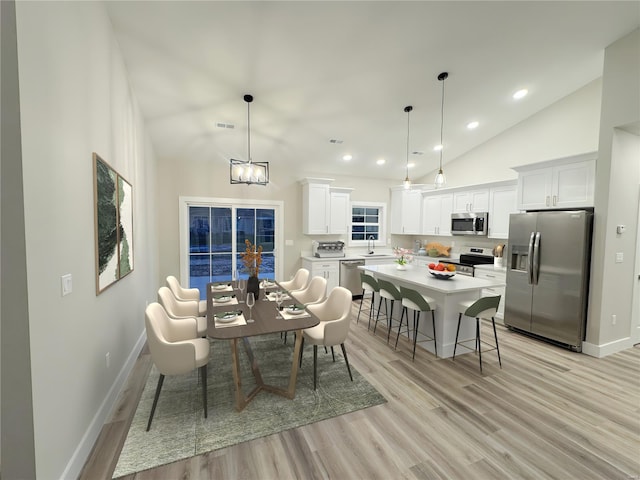 dining room featuring light wood-style flooring, baseboards, a chandelier, lofted ceiling, and recessed lighting