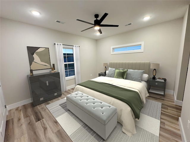 bedroom featuring baseboards, multiple windows, light wood-style floors, and visible vents