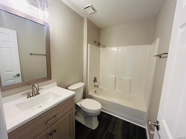 full bathroom featuring vanity, toilet, shower / bath combination, wood finished floors, and visible vents