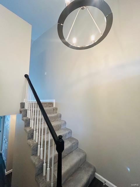 staircase featuring baseboards and wood finished floors