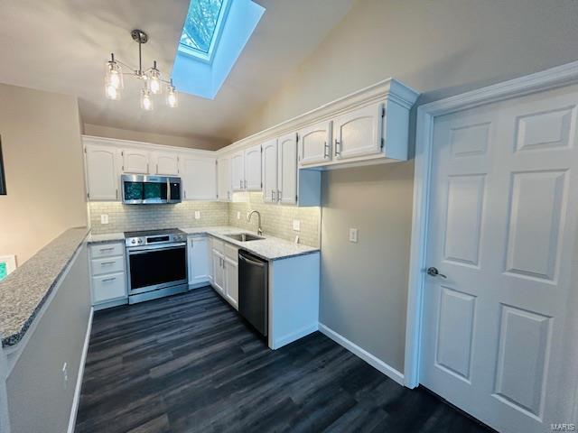 kitchen featuring decorative backsplash, dark wood-style flooring, a sink, white cabinets, and stainless steel appliances