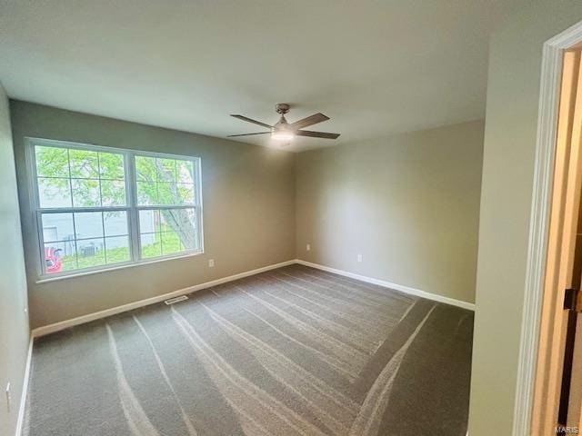 unfurnished room featuring baseboards, a ceiling fan, and dark carpet