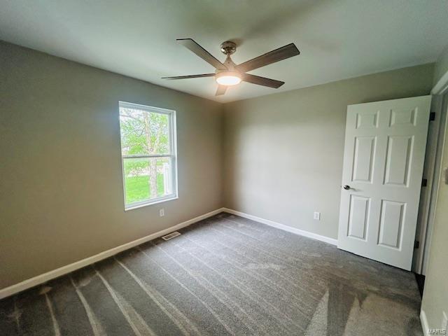 spare room with carpet flooring, a ceiling fan, baseboards, and visible vents
