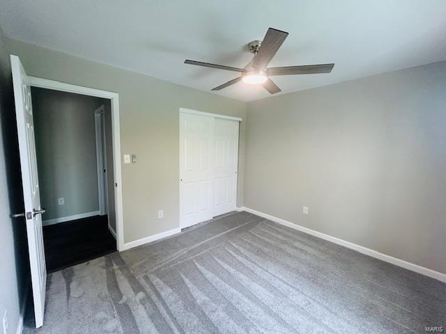 unfurnished bedroom featuring carpet flooring, baseboards, ceiling fan, and a closet