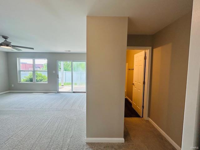 spare room featuring carpet floors, a ceiling fan, and baseboards