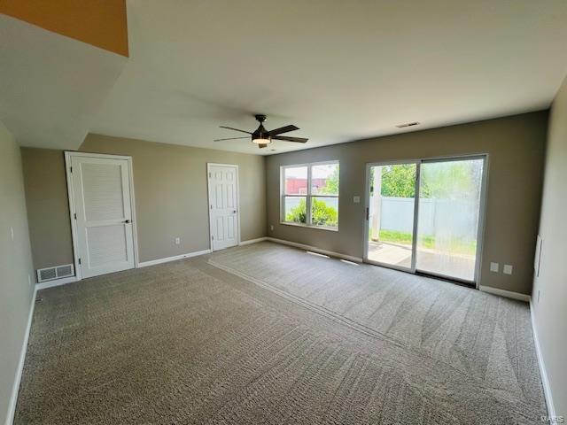 spare room with baseboards, ceiling fan, carpet floors, and visible vents