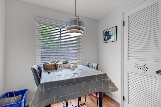 dining space featuring baseboards and wood finished floors