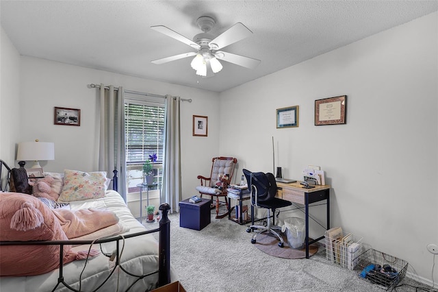 carpeted bedroom with a ceiling fan and a textured ceiling