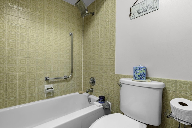 bathroom featuring a wainscoted wall, toilet, tile walls, and shower / tub combination
