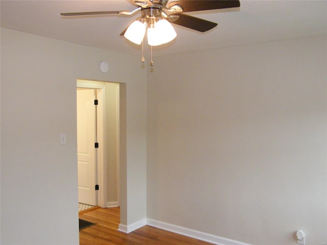 unfurnished room with light wood-style floors, baseboards, and a ceiling fan