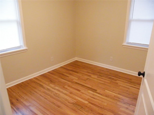 empty room with baseboards and light wood finished floors