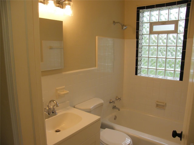 full bath featuring vanity, toilet, tile walls, and bathtub / shower combination