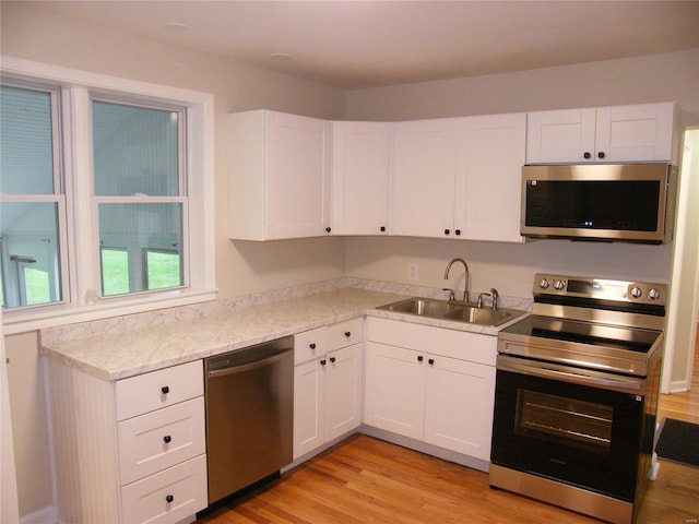 kitchen featuring a sink, appliances with stainless steel finishes, and white cabinetry