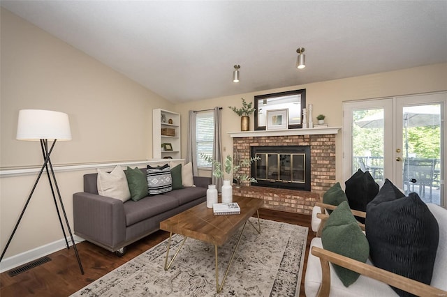 living area featuring a fireplace, french doors, wood finished floors, lofted ceiling, and visible vents