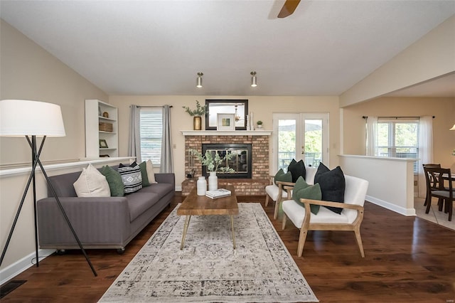 living area featuring baseboards, ceiling fan, a healthy amount of sunlight, and dark wood-type flooring