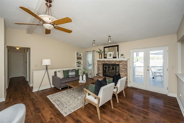 living area featuring ceiling fan, visible vents, a brick fireplace, wood finished floors, and vaulted ceiling with beams