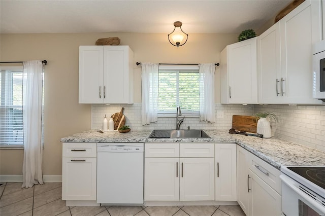 kitchen featuring a sink, tasteful backsplash, white appliances, and light tile patterned flooring